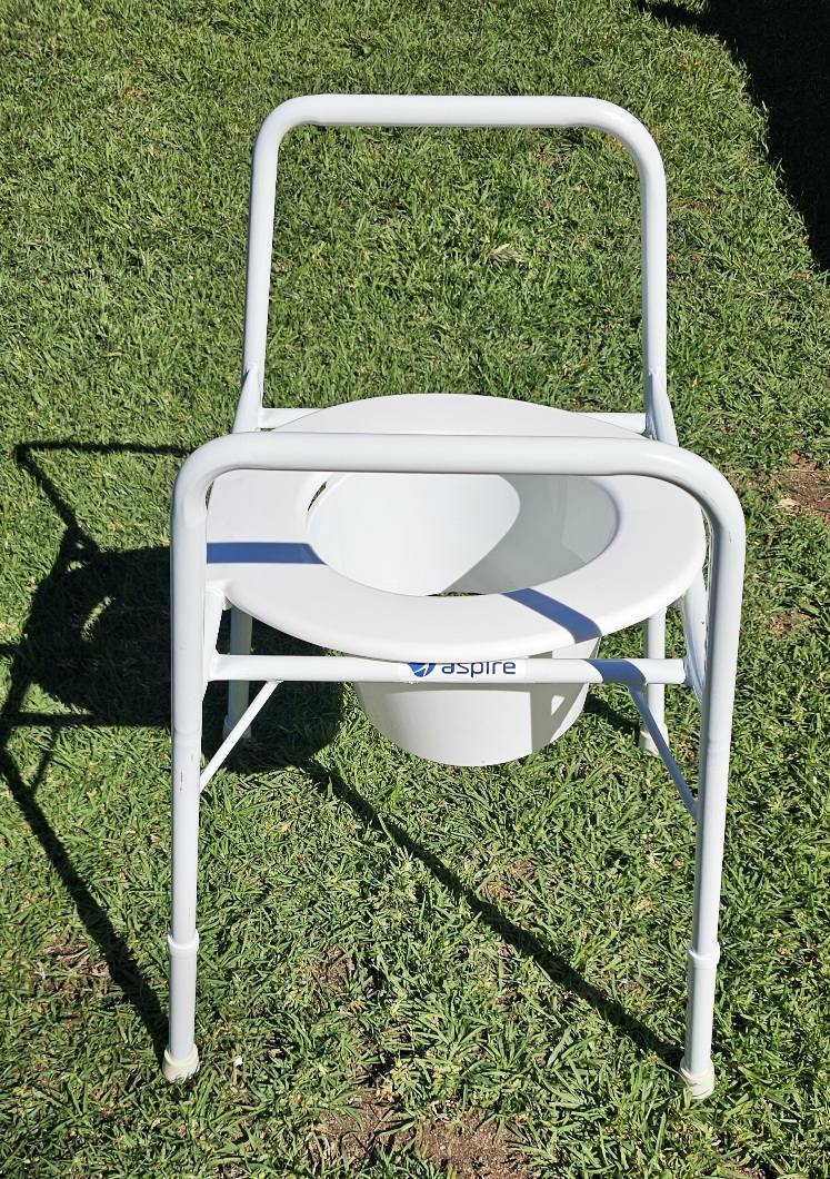 White commode chair with removable bucket and metal frame, shown outdoors to display overall condition and Aspire branding